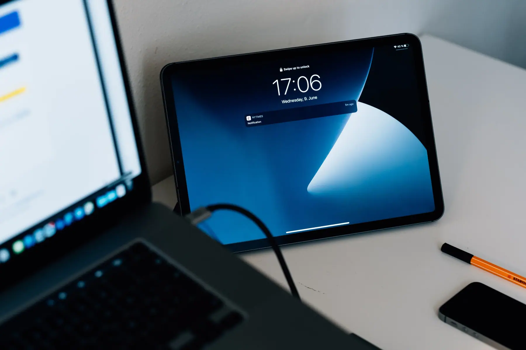 Tablet with a blue screen leaning against a wall